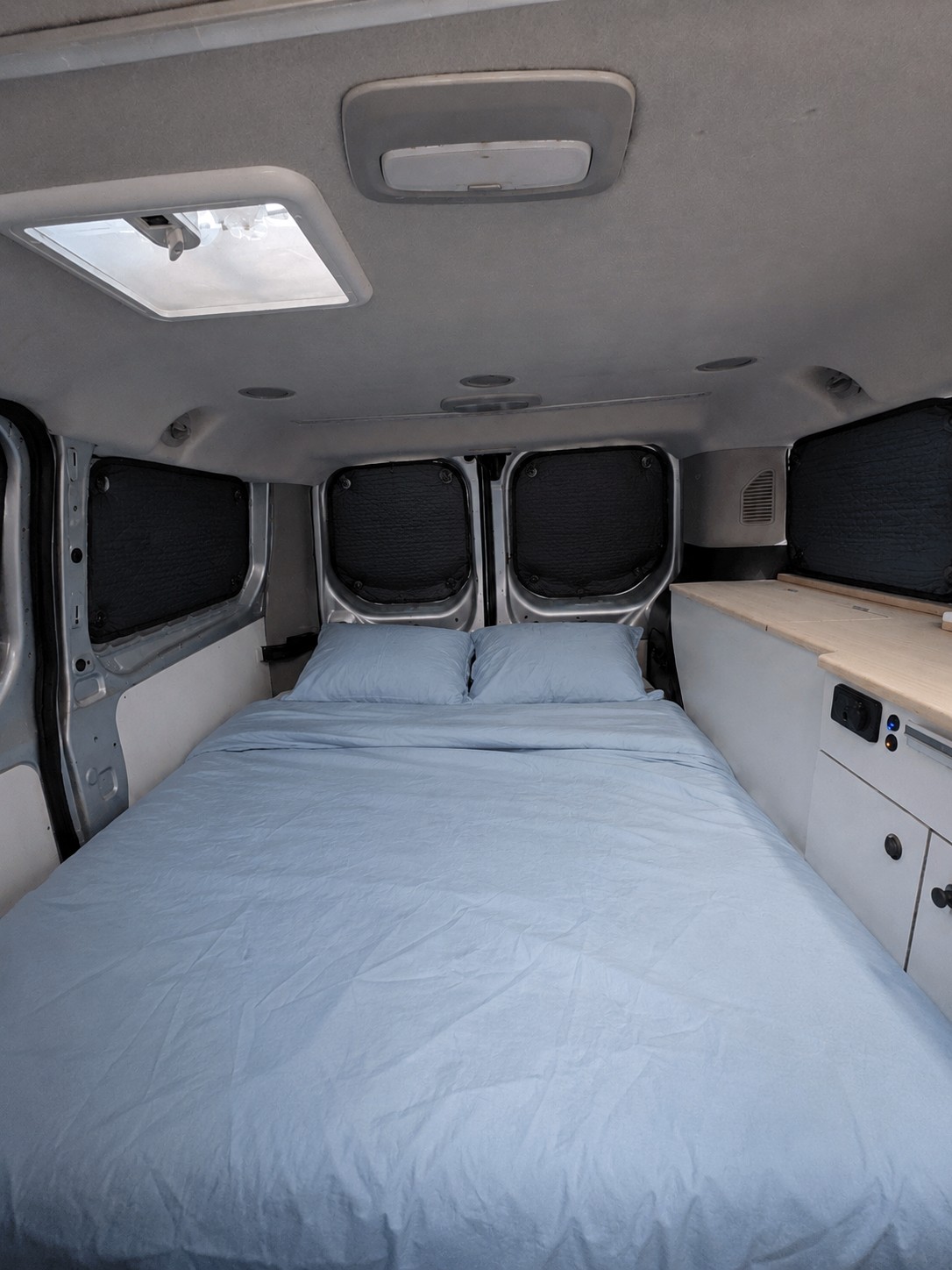 Cama doble en el interior de la furgoneta camper